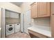 Convenient laundry room featuring a washer, dryer, and built-in storage space at 5946 S Jellison St # F, Littleton, CO 80123