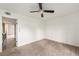 Spacious bedroom with neutral carpet, ceiling fan and light, and an entrance to the staircase at 3550 S Harlan St # 105, Denver, CO 80235