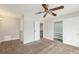 Bright bedroom features neutral walls, carpet, ceiling fan, and closet with sliding doors at 3550 S Harlan St # 105, Denver, CO 80235