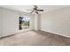 Spacious bedroom with soft carpet, a ceiling fan, and a large window offering neighborhood views at 3550 S Harlan St # 105, Denver, CO 80235