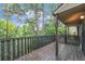 View of a wooden deck with a railing, surrounded by lush greenery and trees, providing a serene outdoor space at 3550 S Harlan St # 105, Denver, CO 80235