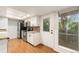Well-lit kitchen with stainless steel appliances, granite counters, and white cabinetry and door to patio or porch at 3550 S Harlan St # 105, Denver, CO 80235