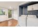 Bright laundry room with washer, dryer, storage cabinets, and convenient access to the exterior at 3550 S Harlan St # 105, Denver, CO 80235
