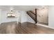 Open-concept living space with hardwood floors and views of the kitchen and staircase at 3550 S Harlan St # 105, Denver, CO 80235