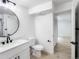 Modern bathroom featuring new vanity, lighting, and tile work next to an open doorway at 19545 E Bates Ave, Aurora, CO 80013