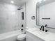 Modern bathroom featuring marble tile, new toilet and vanity with a sleek, frameless mirror at 19545 E Bates Ave, Aurora, CO 80013