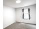 A simple bedroom featuring a window, carpeted floors, and neutral-colored walls at 19545 E Bates Ave, Aurora, CO 80013