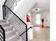 Bright foyer with a staircase, modern lighting, wood floors, and a colorful accent wall at 19545 E Bates Ave, Aurora, CO 80013