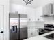 Modern kitchen featuring white cabinets, stainless steel appliances, quartz countertop and sleek hardware at 19545 E Bates Ave, Aurora, CO 80013