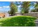 Secluded backyard featuring a well-maintained lawn, patio with seating, storage shed, and a privacy fence at 1221 Ulster St, Denver, CO 80220