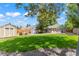 Large grassy backyard with shed, seating area, mature trees, and a hammock for relaxing at 1221 Ulster St, Denver, CO 80220