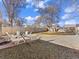 Large, fenced backyard with mature trees, stone groundcover, hammock, and outdoor seating provides a serene outdoor living space at 1221 Ulster St, Denver, CO 80220