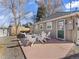 Outdoor patio with white Adirondack chairs, hammock, and exterior home view at 1221 Ulster St, Denver, CO 80220