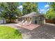 Backyard patio with a seating area, hammock, shed, and mature trees at 1221 Ulster St, Denver, CO 80220