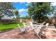 Backyard patio featuring a seating area, mature trees, a shed, and hammock at 1221 Ulster St, Denver, CO 80220