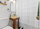 Bathroom featuring a modern glass vessel sink, dark wood vanity, and shower with white curtain at 1221 Ulster St, Denver, CO 80220