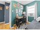 Green accent wall with various pictures and a modern desk and chair creating an inviting workspace at 1221 Ulster St, Denver, CO 80220