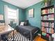 Comfortable bedroom featuring green walls, an accent chair, a desk, and a bookshelf at 1221 Ulster St, Denver, CO 80220