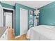 Stylish bedroom featuring blue walls, hardwood floors, closet, and charming decorative string lights above at 1221 Ulster St, Denver, CO 80220