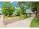 This cozy home features a lush front lawn and attached garage, framed by mature trees, offering great curb appeal at 1221 Ulster St, Denver, CO 80220