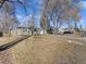 Charming home featuring mature trees, a well-kept lawn, and inviting curb appeal on a sunny day at 1221 Ulster St, Denver, CO 80220