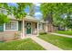 Charming front porch featuring a green door, crisp white trim, and a quaint rocking chair at 1221 Ulster St, Denver, CO 80220