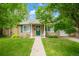 Charming home with a well-manicured front yard, walkway, and cozy rocking chair on the porch at 1221 Ulster St, Denver, CO 80220