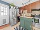 Charming kitchen with an island, dark cabinets, stainless steel refrigerator, and checkered accents with an exterior door at 1221 Ulster St, Denver, CO 80220