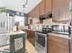 Updated kitchen featuring a dark green kitchen island with brown cabinets and stainless steel appliances at 1221 Ulster St, Denver, CO 80220