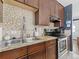 Kitchen featuring granite countertops, mosaic backsplash, and stainless steel appliances at 1221 Ulster St, Denver, CO 80220