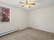 Bright bedroom with large window view, neutral carpet, and ceiling fan at 9385 E Center Ave # 1B, Denver, CO 80247