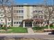 View of the condo building's entrance with a well-maintained lawn and landscaping at 9385 E Center Ave # 1B, Denver, CO 80247