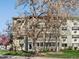 Exterior view of the condominium featuring trees and a well-manicured lawn at 9385 E Center Ave # 1B, Denver, CO 80247