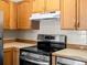 Close up of kitchen featuring stainless steel oven and wooden cabinets at 9385 E Center Ave # 1B, Denver, CO 80247