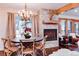 Dining area with a stone fireplace, chandelier, and natural light from large windows at 805 Columbine Rd # 106, Breckenridge, CO 80424