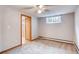 This bedroom features neutral walls, a window for natural light, ceiling fan, and an attached bathroom at 1259 S Elizabeth St, Denver, CO 80210