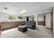 Basement recreational room has light grey carpet, a grey sofa and decorative brick at 356 Aquarius Ct, Littleton, CO 80124