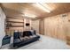 Basement recreational room has light grey carpet, wood-paneled walls and built-in bookshelves at 356 Aquarius Ct, Littleton, CO 80124