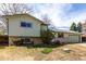 Split-level home featuring a two car garage, charming brick base and sunny sky above at 356 Aquarius Ct, Littleton, CO 80124