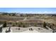 Secluded backyard features a stone patio with comfortable seating and lush landscaping with neighborhood views at 6851 Copper Sky Cir, Castle Pines, CO 80108