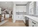 Inviting bar area features white cabinets, stylish backsplash, and a beverage refrigerator at 6851 Copper Sky Cir, Castle Pines, CO 80108