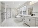 Bright, spacious bathroom featuring a soaking tub, separate shower, double vanity, and white marble tile at 6851 Copper Sky Cir, Castle Pines, CO 80108
