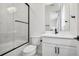 Bathroom featuring shower, bathtub, black hardware, white cabinets and decorative, herringbone shower tiles at 6851 Copper Sky Cir, Castle Pines, CO 80108