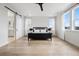 Spacious bedroom with hardwood floors, ample natural light, and sliding barn door to the ensuite bathroom at 6851 Copper Sky Cir, Castle Pines, CO 80108