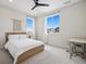 Bright bedroom featuring white walls, plush carpet, ceiling fan, and sunny windows with neighborhood views at 6851 Copper Sky Cir, Castle Pines, CO 80108
