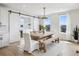 Cozy dining room featuring a barn door, beverage center, and large windows at 6851 Copper Sky Cir, Castle Pines, CO 80108