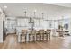 Bright open kitchen with white cabinets, quartz countertops, and a large island at 6851 Copper Sky Cir, Castle Pines, CO 80108