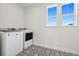 Laundry room with modern washer and dryer, tile floors, white walls, and bright windows with outside views at 6851 Copper Sky Cir, Castle Pines, CO 80108