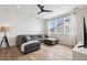 Cozy living room with gray sectional sofa, shiplap walls, hardwood floors and ceiling fan at 6851 Copper Sky Cir, Castle Pines, CO 80108