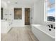 Bright bathroom featuring a modern tub, a frameless glass shower, and dual sinks at 16549 Black Rose Cir, Parker, CO 80134